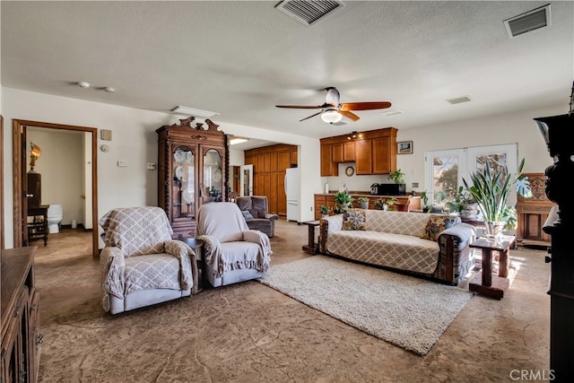 living room with french doors, a textured ceiling, and ceiling fan