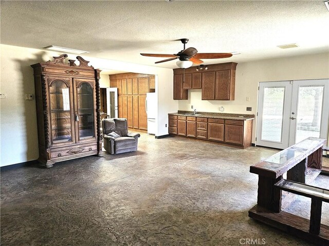 kitchen with ceiling fan, white refrigerator, sink, french doors, and a textured ceiling