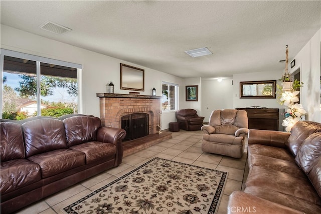 tiled living room featuring a textured ceiling and a fireplace