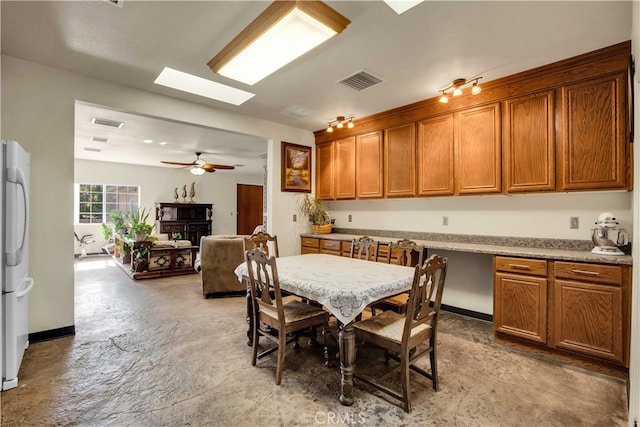 dining room featuring ceiling fan and a skylight