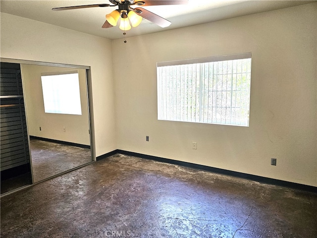 spare room featuring ceiling fan and a wealth of natural light