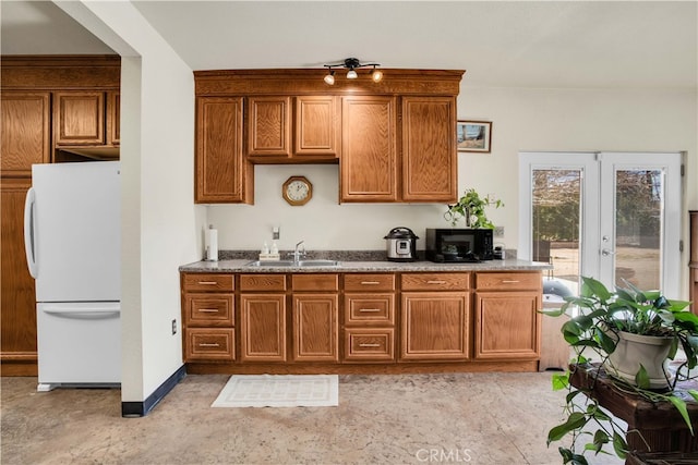 kitchen featuring french doors, white refrigerator, and sink