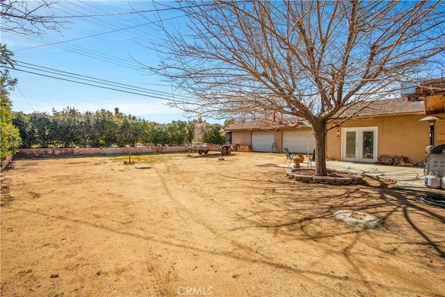 view of yard with french doors and a garage