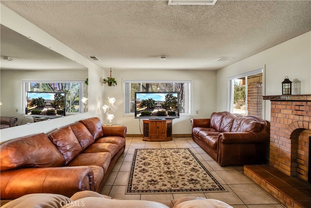 living room featuring a textured ceiling, light tile patterned floors, and a brick fireplace