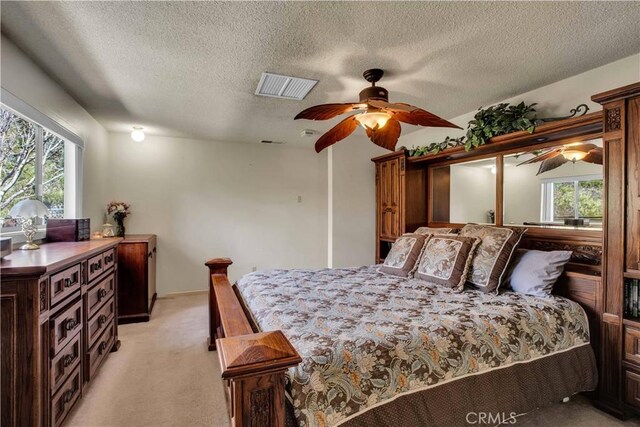 carpeted bedroom with a textured ceiling and ceiling fan