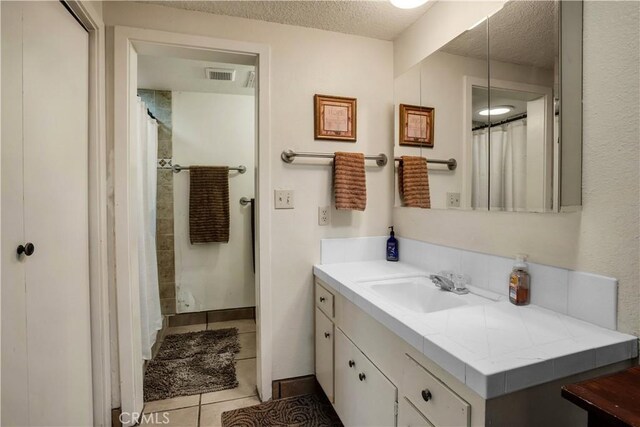 bathroom featuring vanity, a textured ceiling, and tile patterned floors