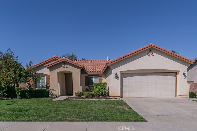 mediterranean / spanish house featuring a front yard and a garage