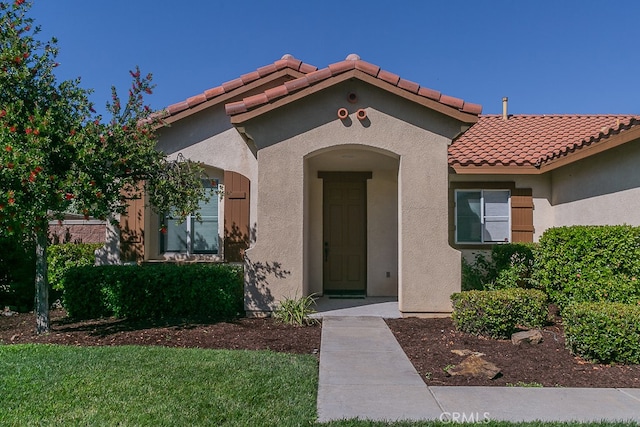 view of exterior entry featuring a yard