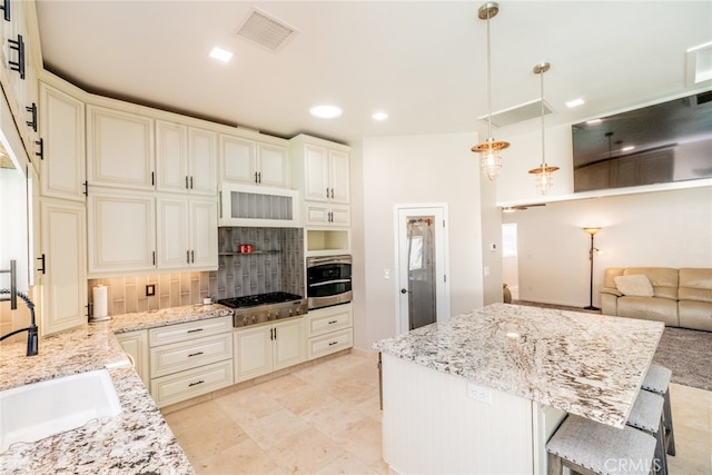 kitchen featuring a kitchen breakfast bar, tasteful backsplash, pendant lighting, stainless steel appliances, and sink