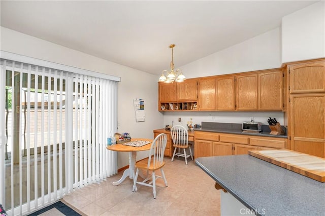 kitchen featuring an inviting chandelier, vaulted ceiling, open shelves, dark countertops, and pendant lighting