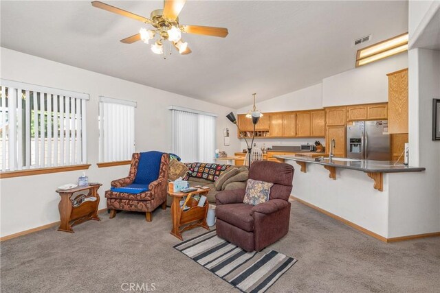 living room with ceiling fan, sink, lofted ceiling, and carpet flooring