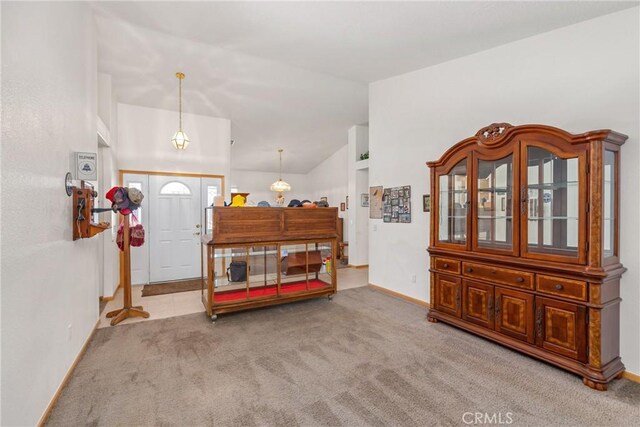 entrance foyer with lofted ceiling and light colored carpet