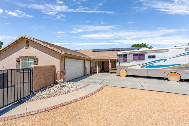 view of front of property with a garage and solar panels