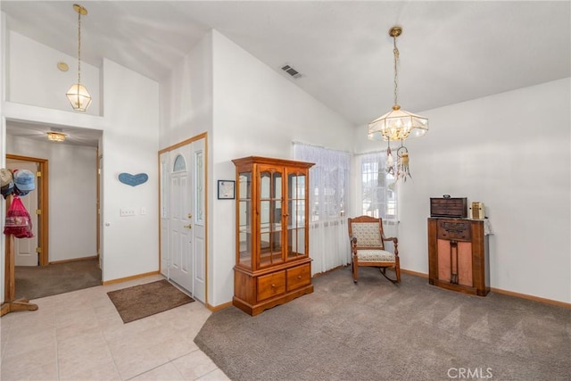 entryway with carpet floors, high vaulted ceiling, baseboards, and visible vents