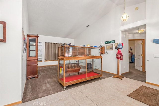 carpeted dining room with high vaulted ceiling, tile patterned floors, and baseboards