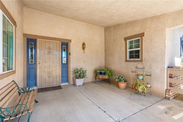 entrance to property with a patio area and stucco siding