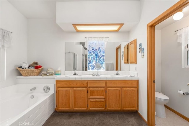 full bathroom featuring double vanity, toilet, a sink, a shower stall, and a bath