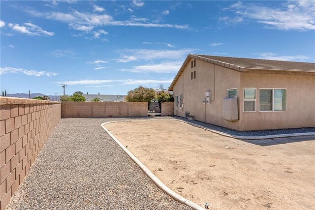 view of side of property with a fenced backyard and stucco siding