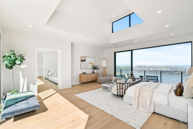 bedroom with a water view and light hardwood / wood-style flooring