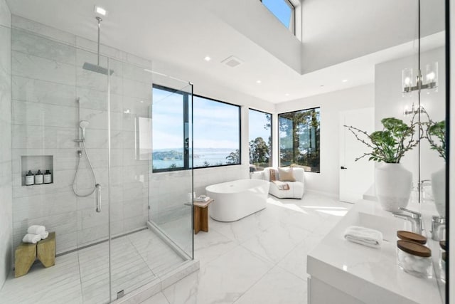 bathroom with vanity, a notable chandelier, separate shower and tub, and a water view