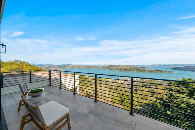 view of patio / terrace with a balcony and a water view