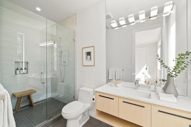 bathroom featuring vanity, tile patterned flooring, a shower with door, and toilet