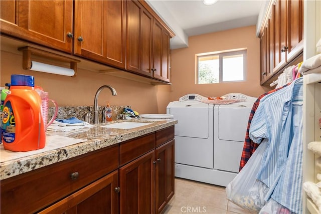 laundry area with cabinets, light tile patterned floors, sink, and washing machine and clothes dryer