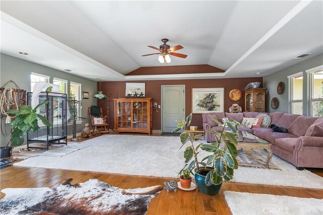 living room with a tray ceiling, ceiling fan, lofted ceiling, and hardwood / wood-style flooring