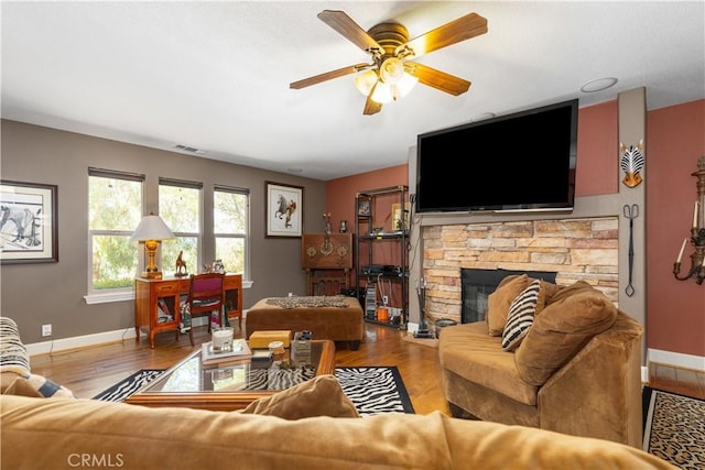 living room featuring a fireplace, wood-type flooring, and ceiling fan