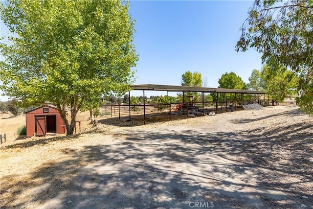 view of yard with a rural view and a storage shed