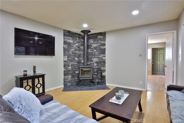 living room with wood-type flooring and a wood stove