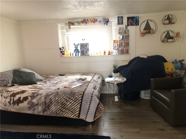 bedroom with a textured ceiling and wood-type flooring