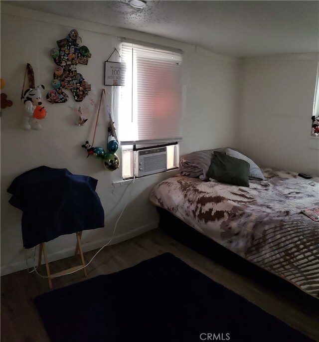 bedroom featuring hardwood / wood-style flooring and cooling unit