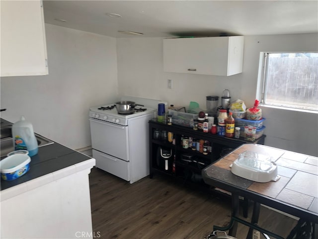 kitchen with tile countertops, white cabinetry, dark wood-type flooring, and white stove