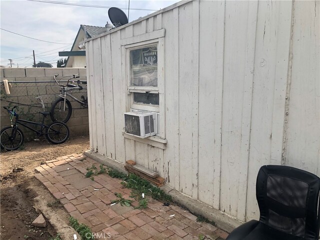 view of property exterior featuring a patio area, a shed, and cooling unit