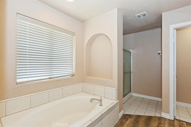 bathroom featuring wood-type flooring and plus walk in shower