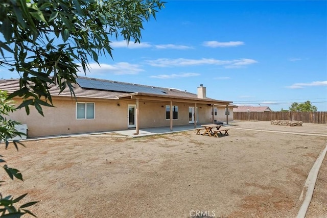 rear view of house featuring solar panels and a patio