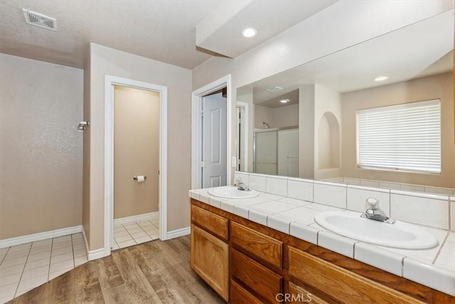 bathroom featuring an enclosed shower, vanity, and hardwood / wood-style flooring