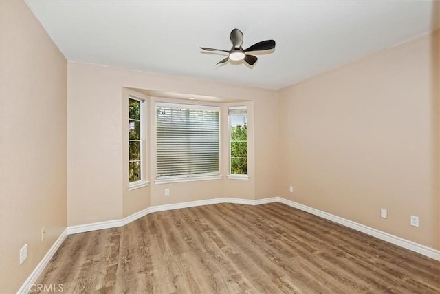 empty room with hardwood / wood-style floors and ceiling fan