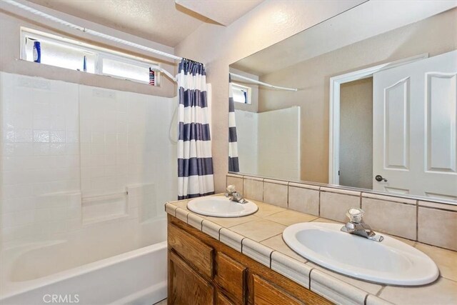 bathroom featuring backsplash, vanity, and shower / tub combo with curtain