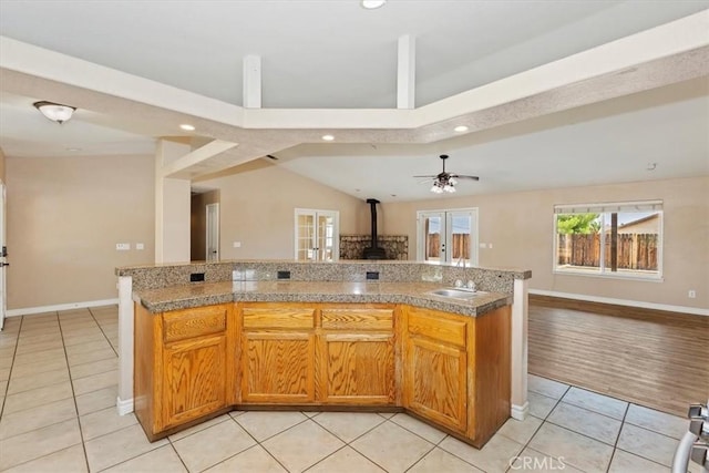 kitchen featuring ceiling fan, light tile patterned floors, sink, and a center island