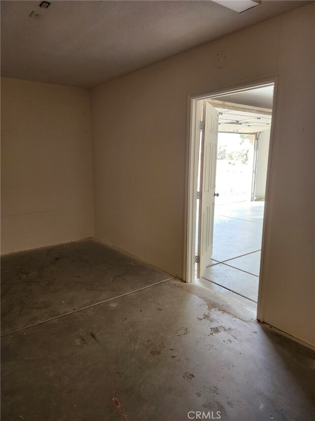 unfurnished room featuring concrete flooring