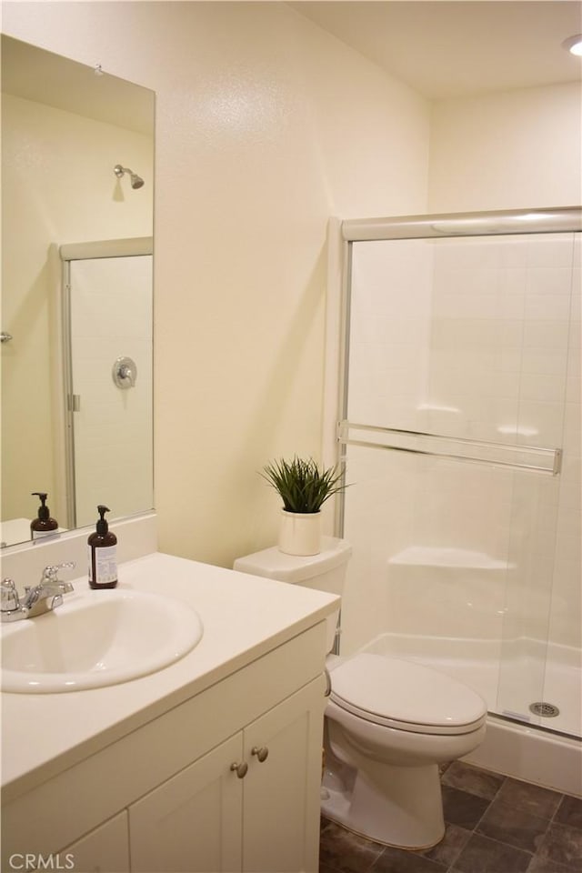 bathroom with vanity, toilet, and a shower with shower door