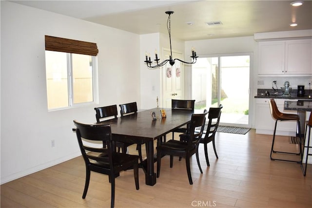 dining space with a chandelier and light hardwood / wood-style floors