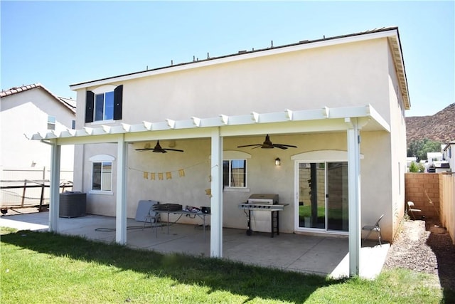 rear view of property with a lawn, a patio area, and ceiling fan