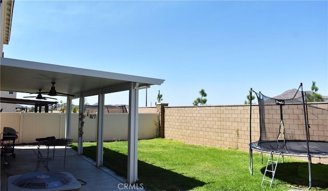 view of yard with ceiling fan, a patio area, a trampoline, and central air condition unit