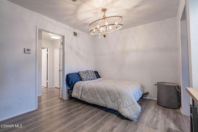 bedroom featuring hardwood / wood-style floors and a notable chandelier