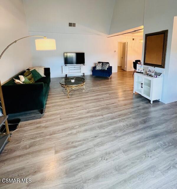 living room with a high ceiling and light wood-type flooring