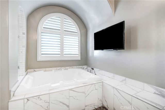 bathroom featuring tiled tub