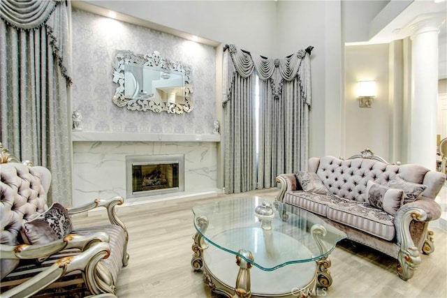 living room with ornate columns and hardwood / wood-style floors